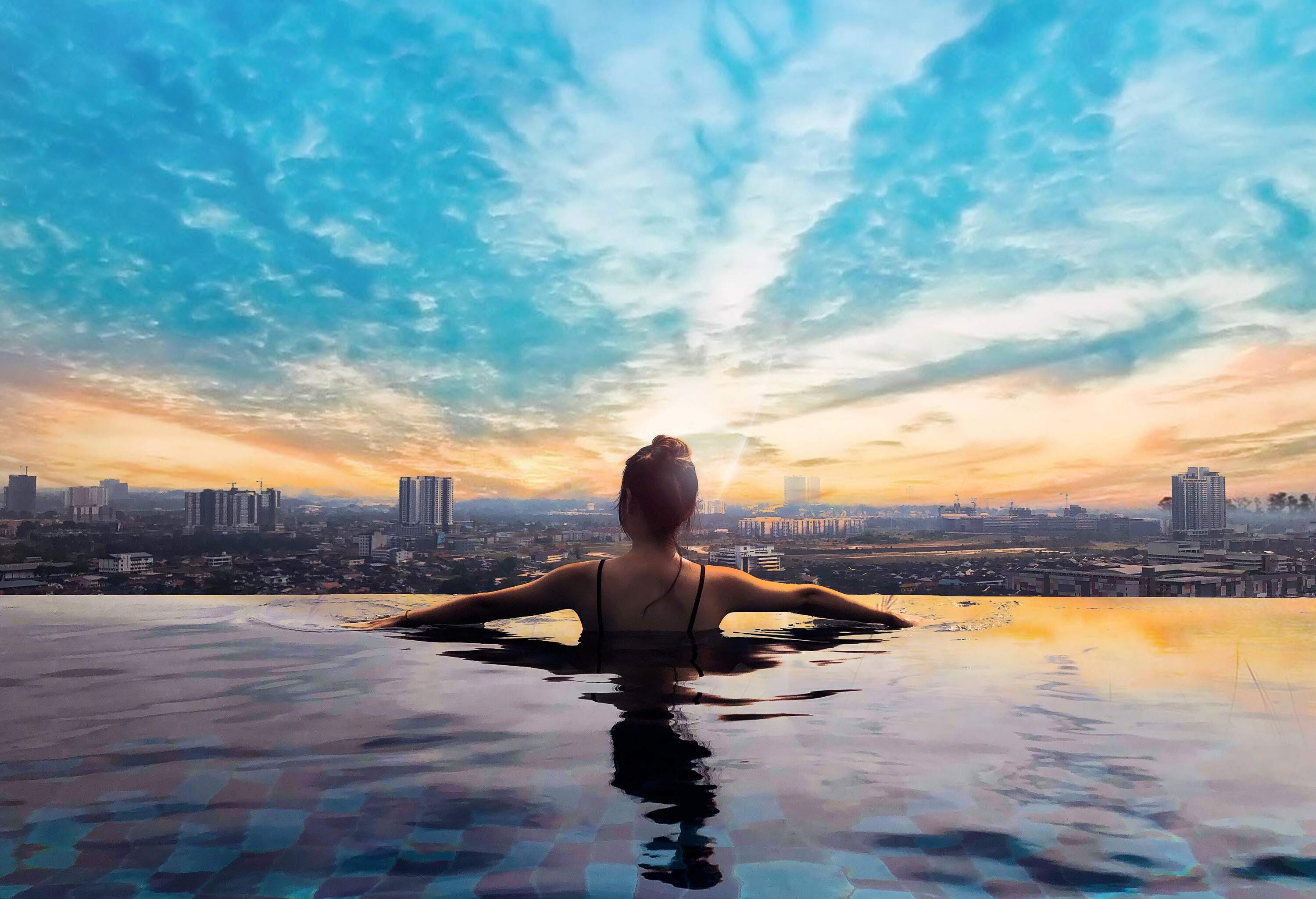 theme_person_pool_sunset_rooftop-shutterstock-portfolio_1158636064