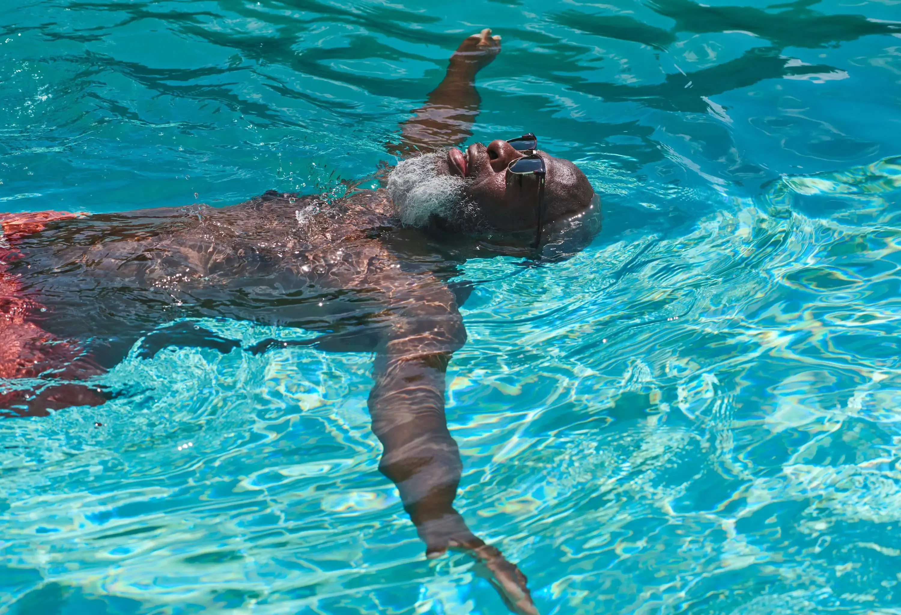 dest_spain_ibiza_hotel_pool_man_relaxes_gettyimages-1192125536